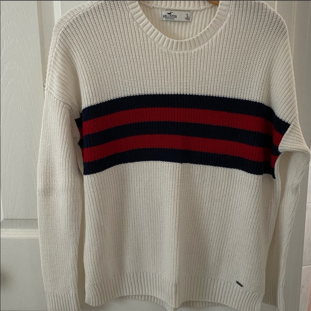 White cable knit sweater, red and blue stripes.